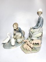 Lladro girl seated with five piglets, 28cm, and girl with two ducks, 17.5cm.