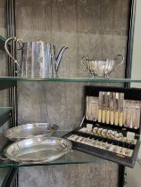 A collection of silver plate, a muffin dish with lid, tea pot, sugar bowl and a canteen of cutlery.