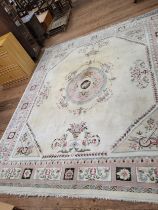 A large Chinese cream ground rug, with polychrome decoration. 270cm x 300cm. In a used condition.