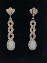 A pair of silver and opal drop earrings, the ribbon-twist mounts set with white cubic zirconia, 3.