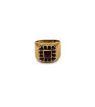 A yellow metal and garnet gents ring, set with a square cluster of mixed rose-cut and faceted