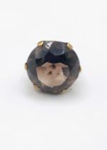 A 9ct yellow gold and smoky quartz cocktail ring, set with a large round-cut quartz, measuring