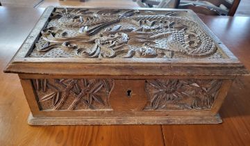 A carved wooden box containing sundries