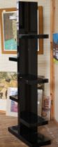 A black shelving tower with staggered shelves. 187cm x 72cm x 28cm