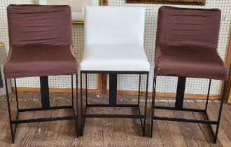 Three tall cream leather stool chairs. Two stools have removable covers as the leather beneath has