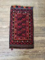 A double stitched red, black, and orange rug. 117cm x 64cm.
