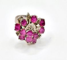 A ruby cluster ring, set with mixed cut rubies, with leaf motif detail inset with small white