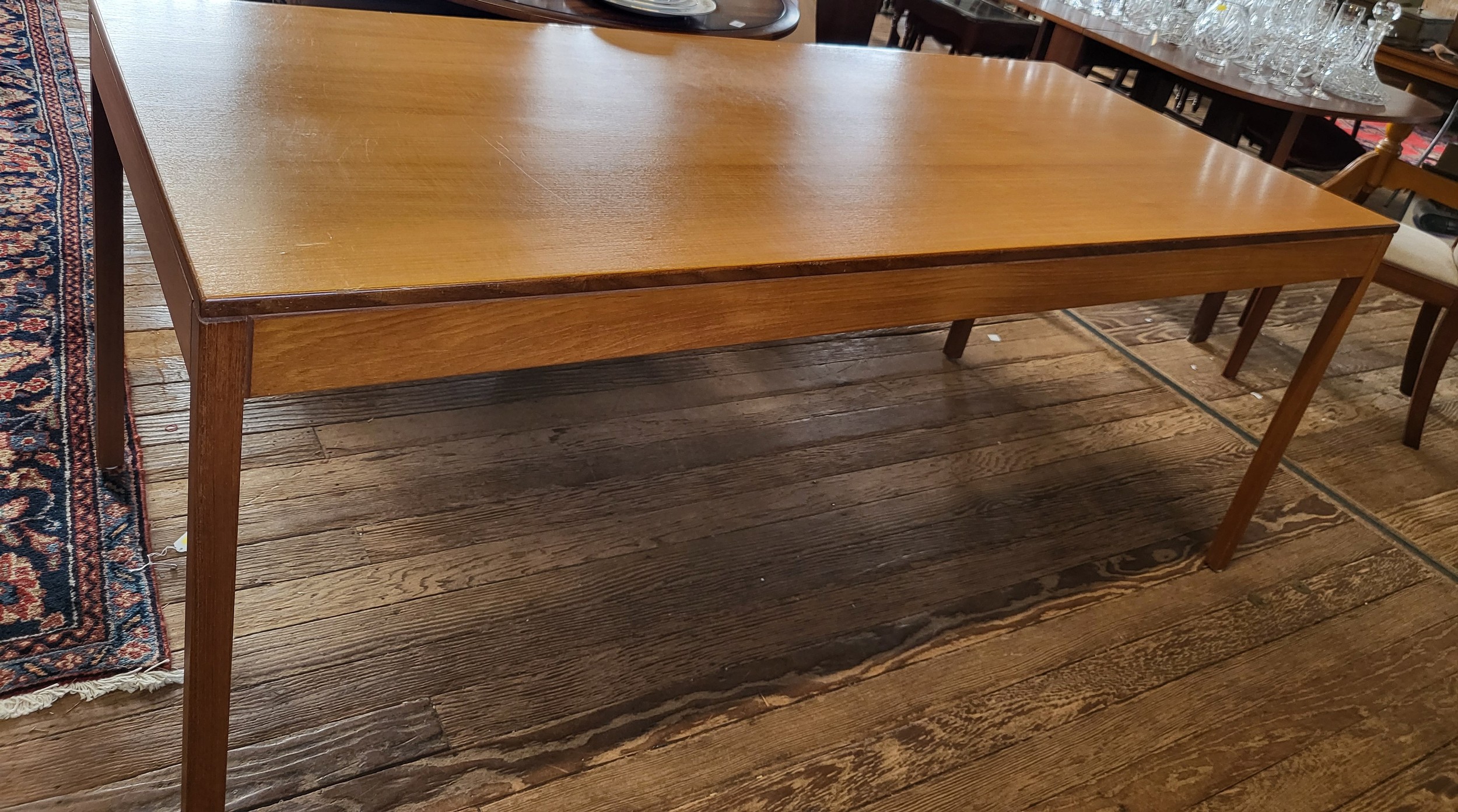 A mid 20th century teak dining table, of rectangular design, supported on four straight legs (