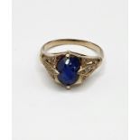 A yellow metal and sapphire ring, set with a mixed oval-cut sapphire, the openwork mount inset