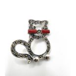 A silver and marcasite cat brooch with red whiskers, and marcasite detail.