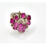 A ruby cluster ring, set with mixed cut rubies, with leaf motif detail inset with small white