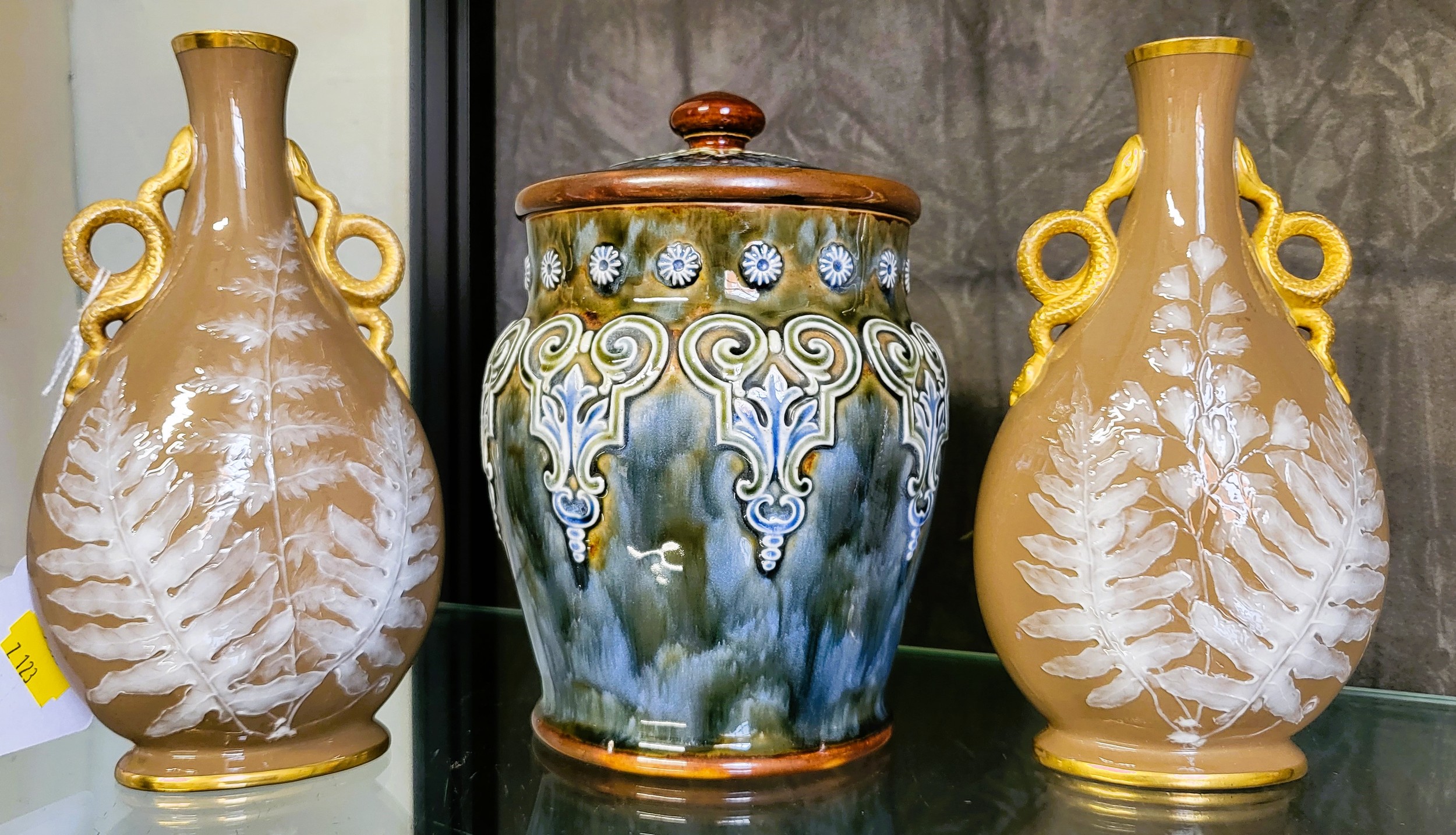 A Royal Doulton Stoneware lidded jar, 18cm high, and a pair of pâte-sur-pâte bottle vases with