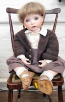 Celia Doll Company 'Charly' bisque head doll, 55cm, with certificate. No 64 of 200, seated on an