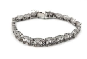 A silver and cubic zirconia segmented line bracelet. 17.5cm long.