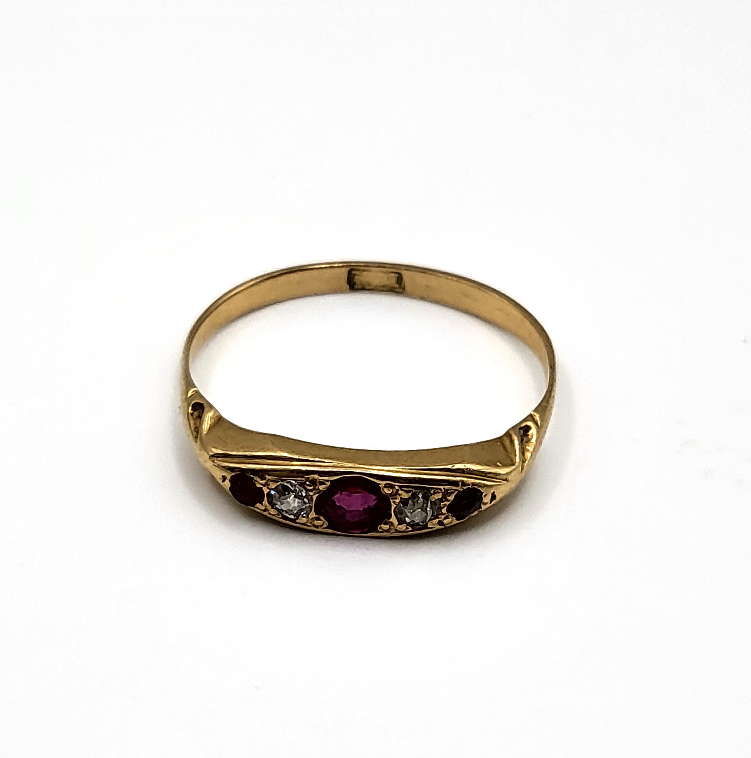 An 18ct yellow gold, diamond, and ruby ring, set with a larger round-cut ruby, two old-cut diamonds,