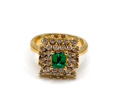 An 18ct yellow gold, diamond, and emerald cluster ring, centred with a mixed emerald-cut emerald,