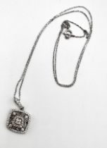 An 18ct white gold and diamond pendant, the squared openwork mount inset with round brilliant-cut