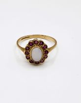 A 9ct yellow gold, ruby and opal ring, set with an oval cabochon opal, the round-cut rubies set in a