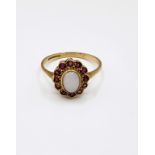 A 9ct yellow gold, ruby and opal ring, set with an oval cabochon opal, the round-cut rubies set in a