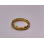 A plain yellow gold wedding band ring, marked 916 to shank, size N.