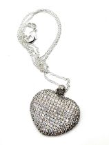 A large silver and cubic zirconia heart-shaped pendant, suspended on a silver chain.