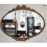 An oval wall mirror with gilt cast metal frame. 45cm x 57cm.