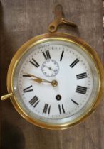 A Victorian brass ship's clock with key. 17cm diameter.