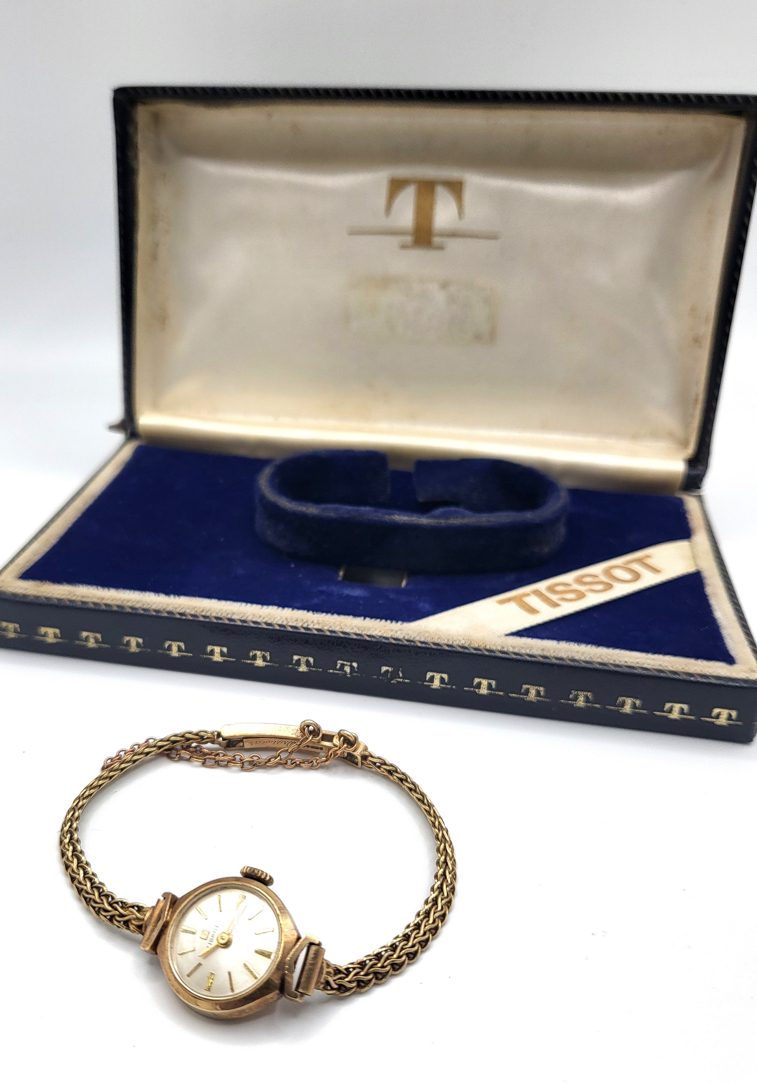 A Tissot 9ct gold ladies watch on an articulated bracelet and safety chain in the original