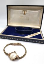 A Tissot 9ct gold ladies watch on an articulated bracelet and safety chain in the original