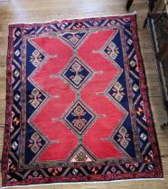 An Afshar blue and red ground Persian rug, with diamond medallion design. 190cm x 155cm.