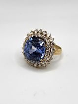 A large and impressive sapphire and diamond ring, set with a mixed cushion-cut natural sapphire,