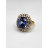 A large and impressive sapphire and diamond ring, set with a mixed cushion-cut natural sapphire,