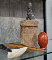 A carved African fertility figure, a carved bone ceremonial spoon, a turned wooden pot, and a pair