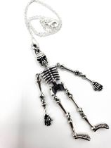 An unusual articulated silver skeleton pendant necklace, suspended on a silver chain. Pendant 8.5cm.