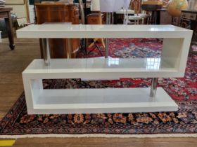 A white high-gloss Dwell three-tiered display table. 65cm x 120cm x 35cm