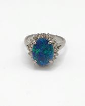 A platinum, diamond, and black opal doublet ring, the opal measuring approximately 12.4 x 9.5 mm,