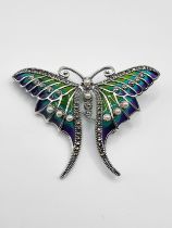 A silver and plique a jour pendant brooch, in the form of a butterfly, decorated with blue and green