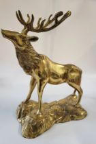 A brass model of a stag on a naturalistic plinth. 38cm x 28 cm.