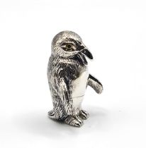 A small silver figure of a penguin. 3cm high.