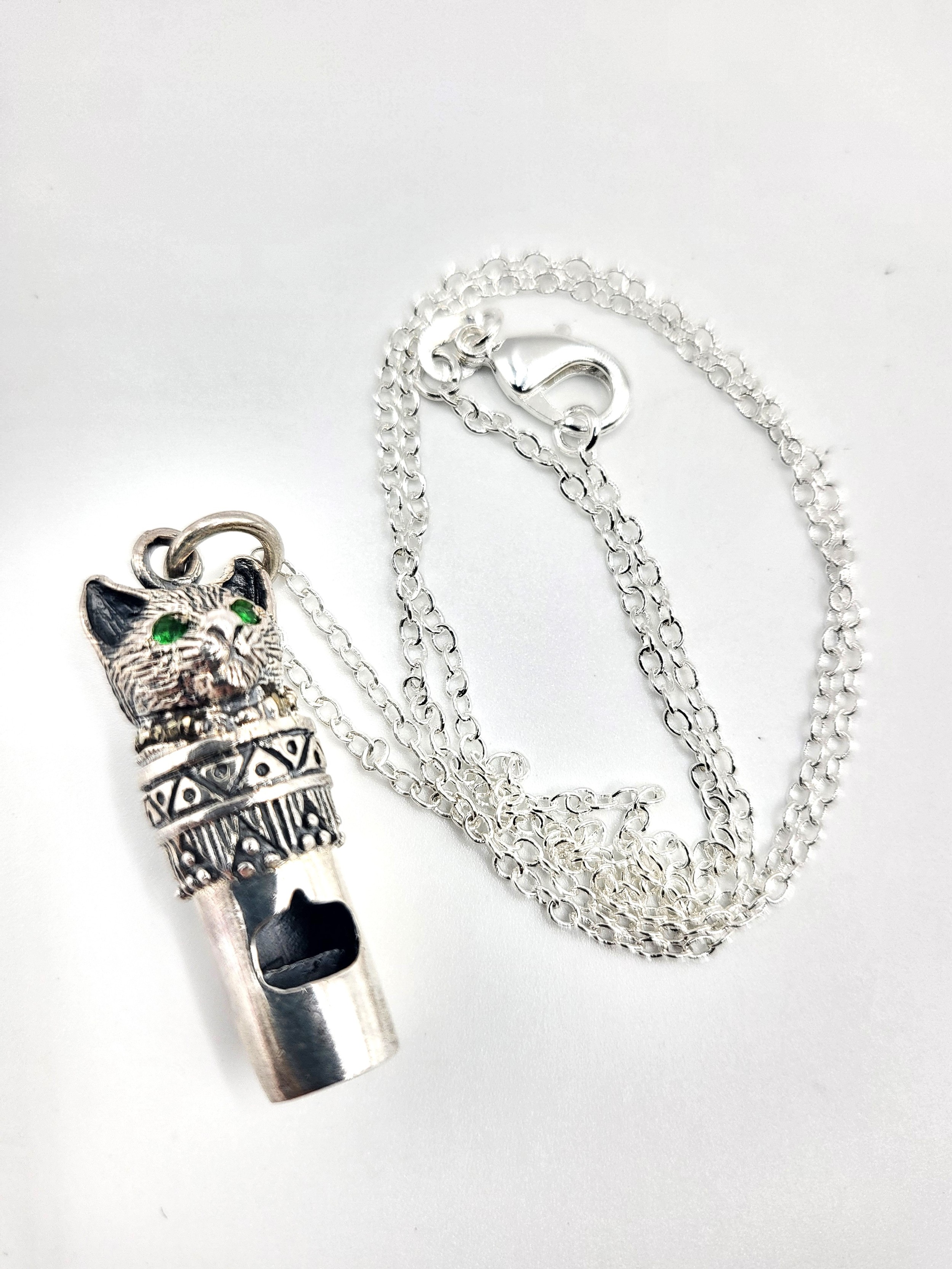 A novelty silver pendant whistle in the form of a cat, suspended on a silver chain. 3.2cm