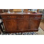 A large mahogany sideboard with three drawers over three cupboards. 79cm x 140cm x 40cm.