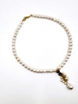 A freshwater pearl necklace, suspended with an amethyst and pearl drop pendant, gilt metal clasp.