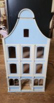 A blue painted wooden doll's house, four storeys. Unfurnished.