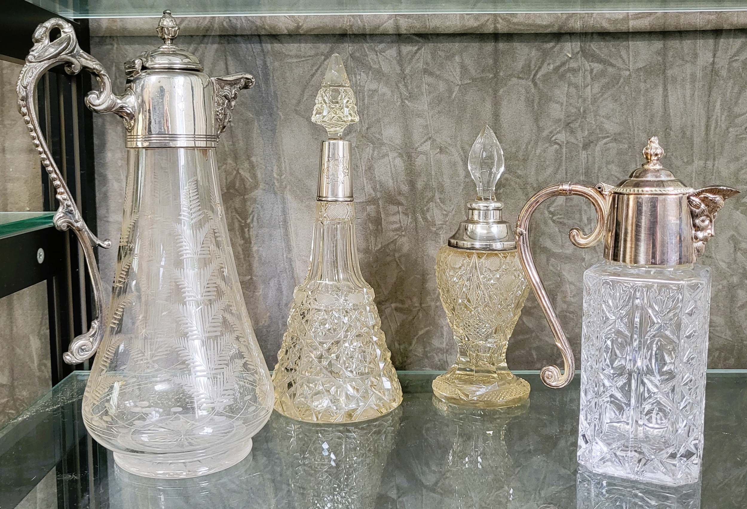 A cut glass and silver plate claret jug, a silver plate and cut glass decanter, and two cut glass