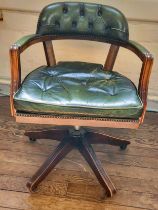 A captain's chair with green leather button back and seat, green leather on arms, stud finish to