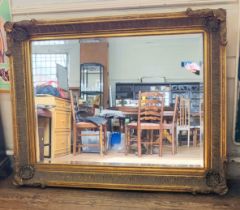 A large ornate bevelled mirror with gilt scrolling. 150cm x 120cm.