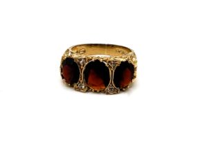 A 9ct yellow gold and garnet and white topaz ring, set with three mixed oval-cut garnets and four