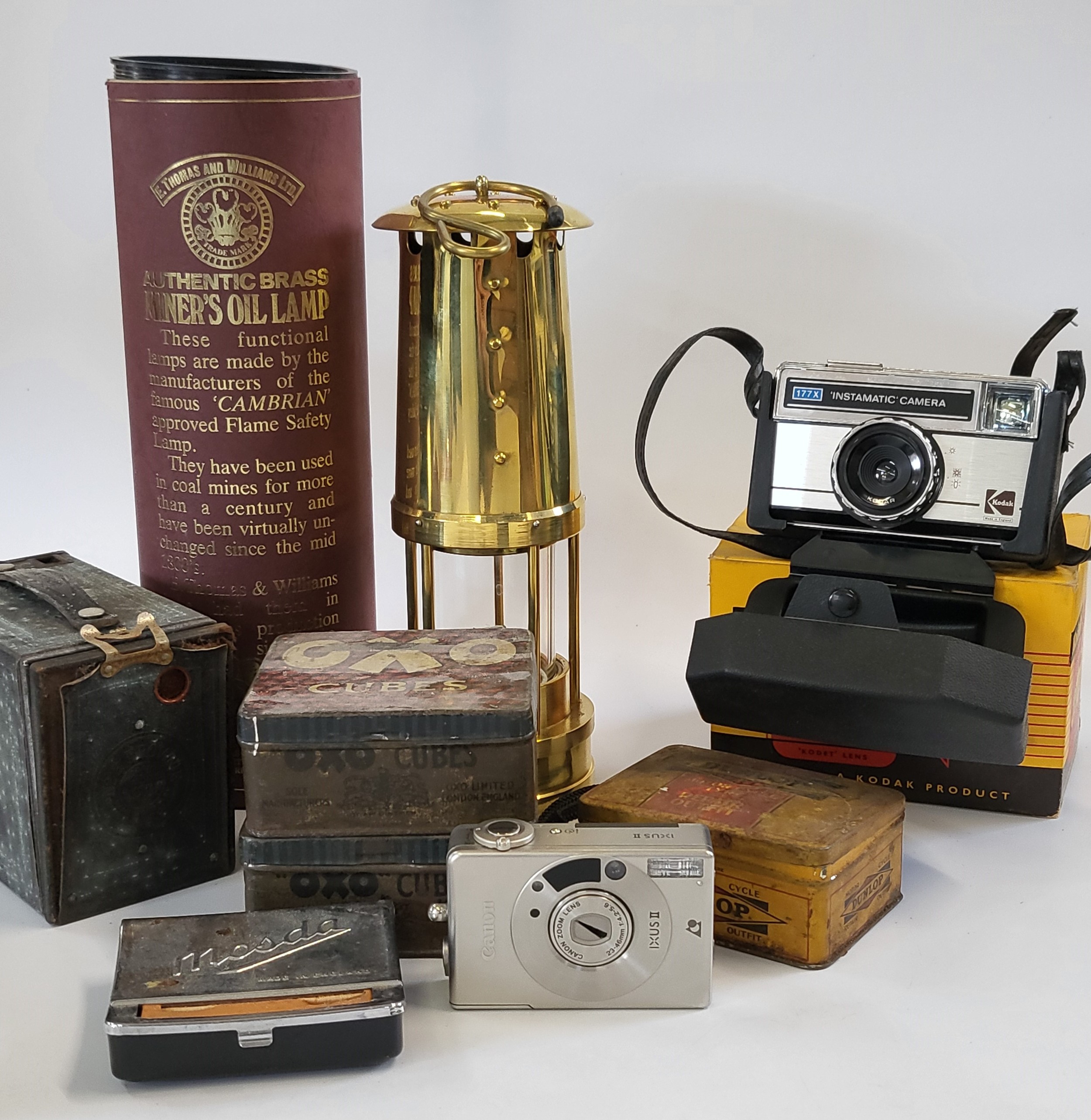 A collection of metalware items including an oil lamp and tins, together with a camera (Brownie) and