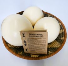 Three ostrich eggs and an African woven basket