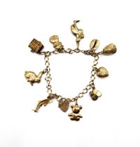 A 9ct yellow gold charm bracelet, suspended with 9ct charms including baby shoes, a stork, a rabbit,